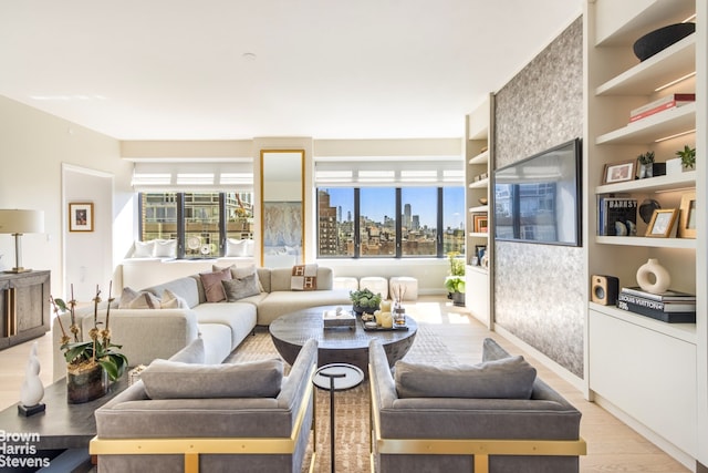 living area featuring built in shelves and light wood-style flooring