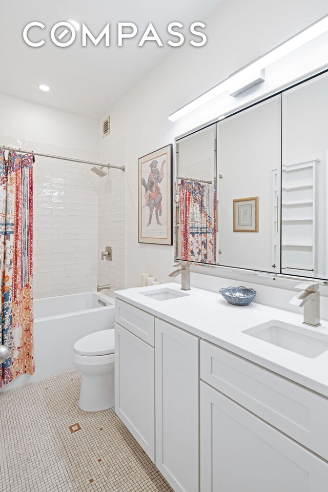 bathroom with a sink, visible vents, double vanity, and tile patterned floors