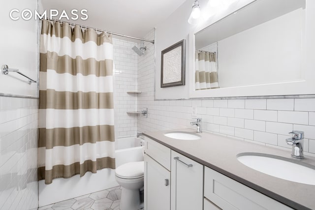 full bathroom featuring double vanity, shower / bath combination with curtain, tile walls, and a sink