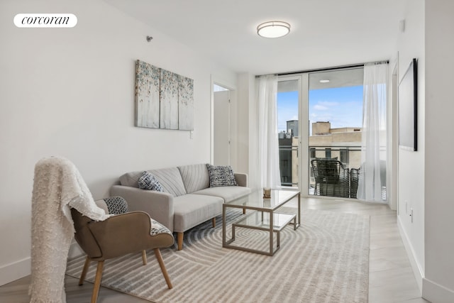 living area featuring a wall of windows, visible vents, baseboards, and light wood finished floors