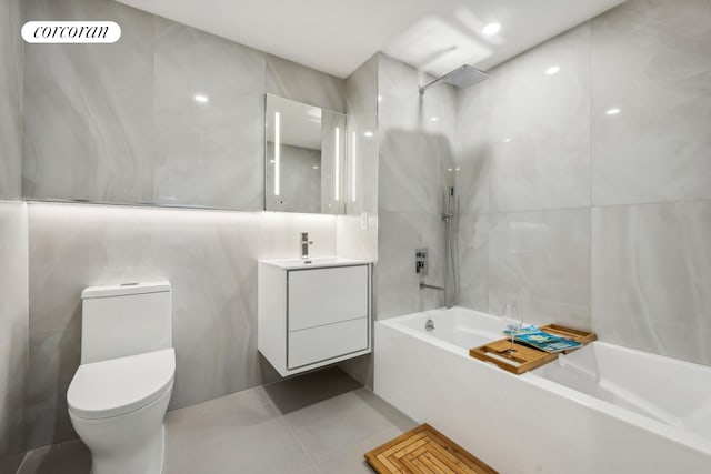 full bathroom featuring tile walls, vanity, toilet, and shower / bathing tub combination