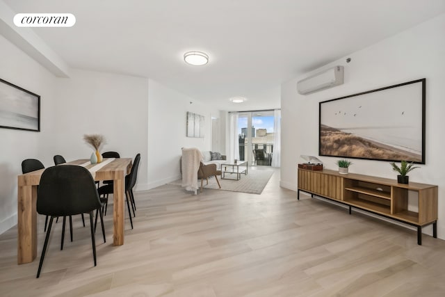 dining area featuring a wall mounted air conditioner, visible vents, floor to ceiling windows, light wood finished floors, and baseboards