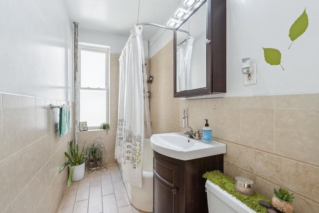 bathroom featuring shower / tub combo with curtain, tile walls, toilet, vanity, and tile patterned flooring