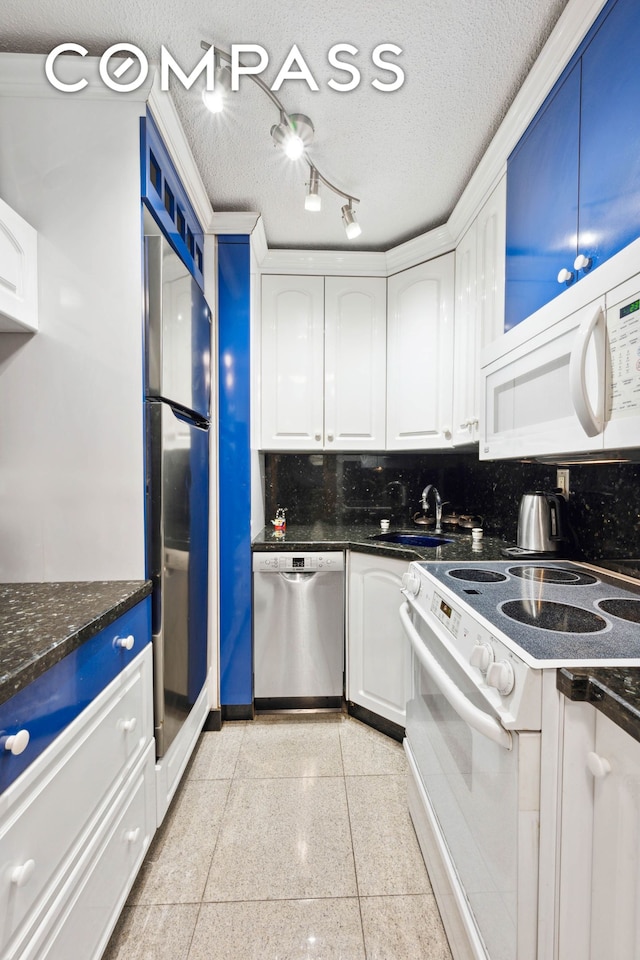 kitchen with tasteful backsplash, appliances with stainless steel finishes, a textured ceiling, white cabinetry, and a sink