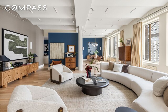 living room featuring lofted ceiling, baseboards, and wood finished floors