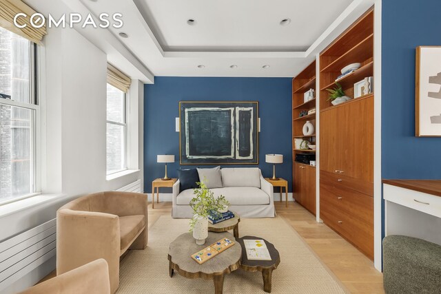 114 Liberty St Unit 7, New York City, NY 10006 - living room with light wood finished floors, built in features, a tray ceiling, and recessed lighting