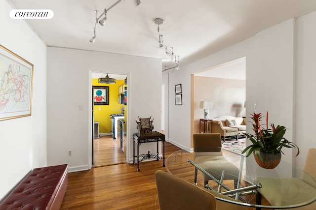 interior space with visible vents, rail lighting, baseboards, and wood finished floors