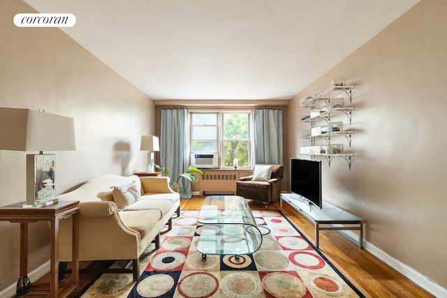 living room featuring visible vents, radiator, baseboards, cooling unit, and wood finished floors