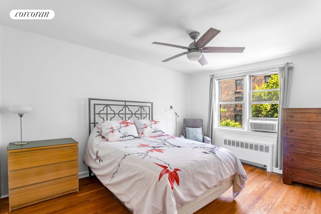 4 Bogardus Pl Unit 3E, New York City, NY 10040 - bedroom with radiator, wood finished floors, a ceiling fan, and cooling unit