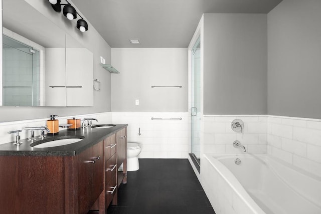 full bathroom featuring tile patterned floors, vanity, tile walls, toilet, and separate shower and tub