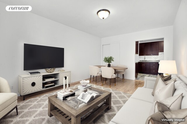 living room with sink and light hardwood / wood-style flooring