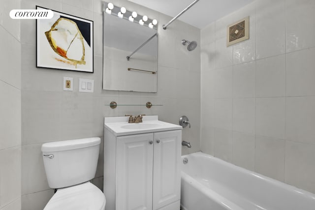 bathroom featuring toilet, shower / bathing tub combination, tile walls, and vanity