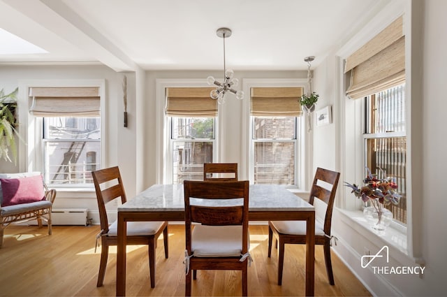 dining area with a chandelier, plenty of natural light, and light wood-style flooring