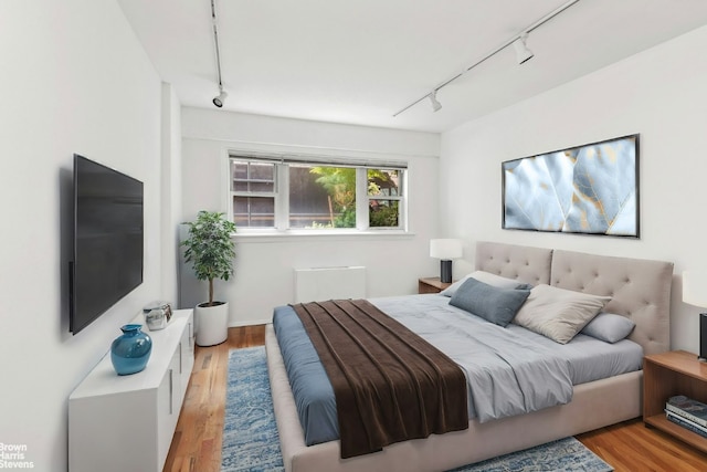 bedroom featuring light hardwood / wood-style floors and rail lighting