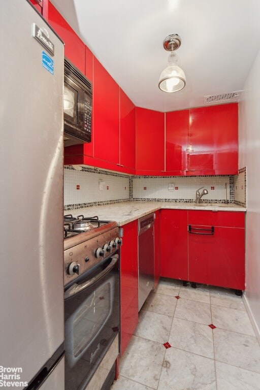 kitchen with appliances with stainless steel finishes and decorative backsplash