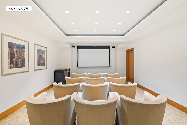 cinema room featuring visible vents, light colored carpet, and a tray ceiling