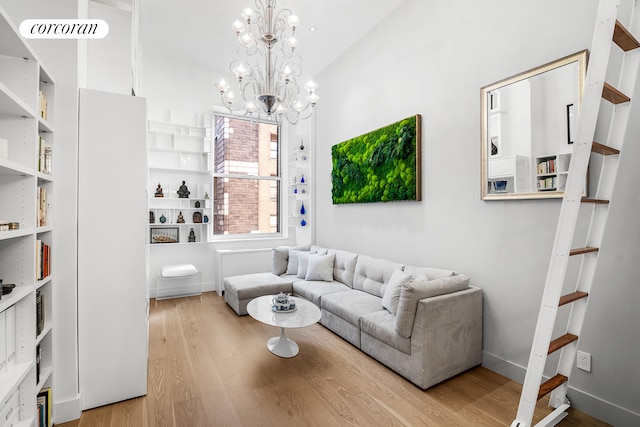 living room with a chandelier, visible vents, baseboards, and wood finished floors