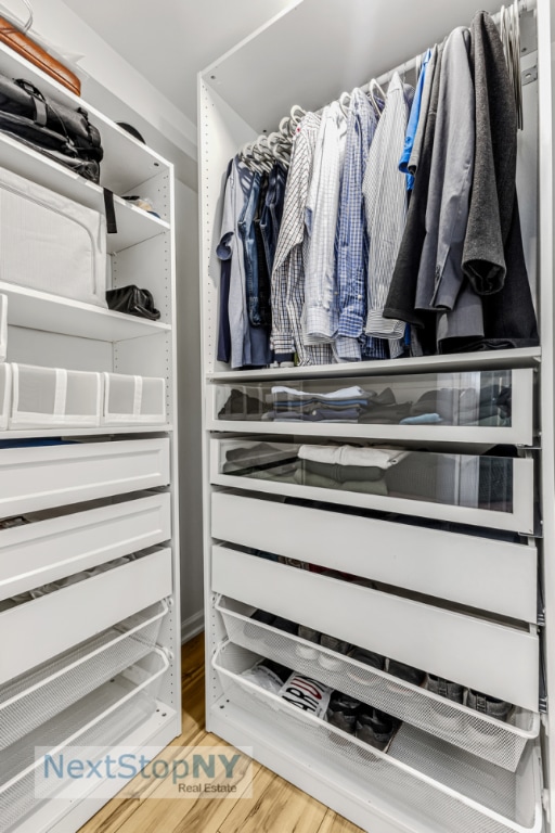 walk in closet with wood-type flooring