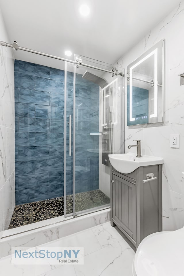 full bathroom with marble finish floor, toilet, a shower stall, and vanity