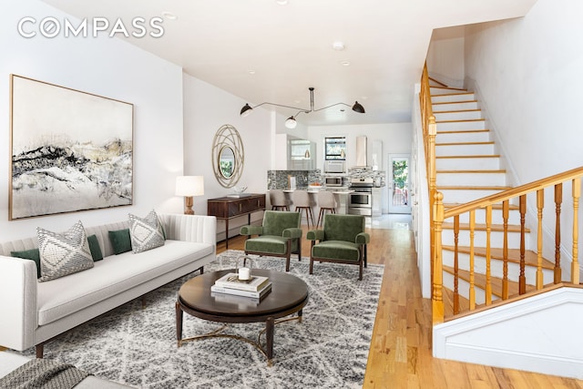 living room featuring light wood-style floors and stairway