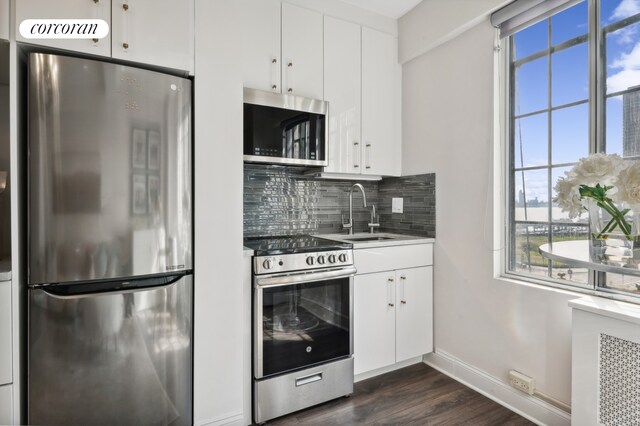 kitchen featuring decorative backsplash, sink, white cabinets, and appliances with stainless steel finishes