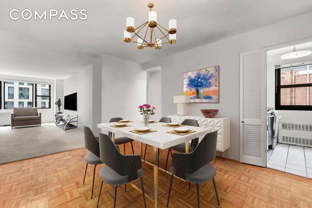 dining room with light parquet flooring, radiator heating unit, plenty of natural light, and a chandelier