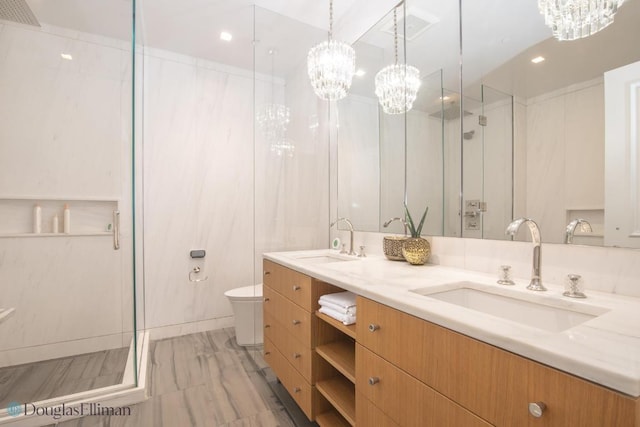 bathroom featuring an enclosed shower, vanity, toilet, and an inviting chandelier