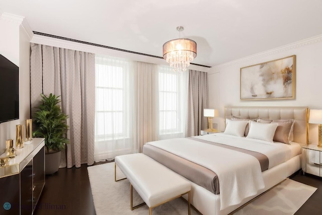 bedroom featuring dark hardwood / wood-style floors, crown molding, and a chandelier