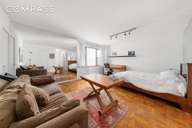 bedroom with parquet floors and track lighting