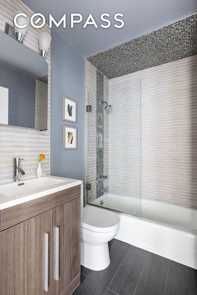 full bathroom with tasteful backsplash, toilet, wood finished floors, enclosed tub / shower combo, and vanity