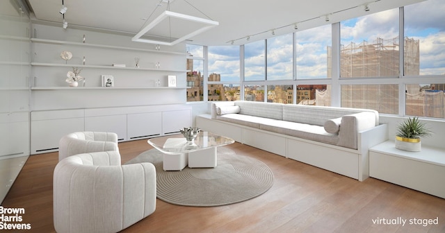 sunroom / solarium with a view of city, plenty of natural light, and track lighting