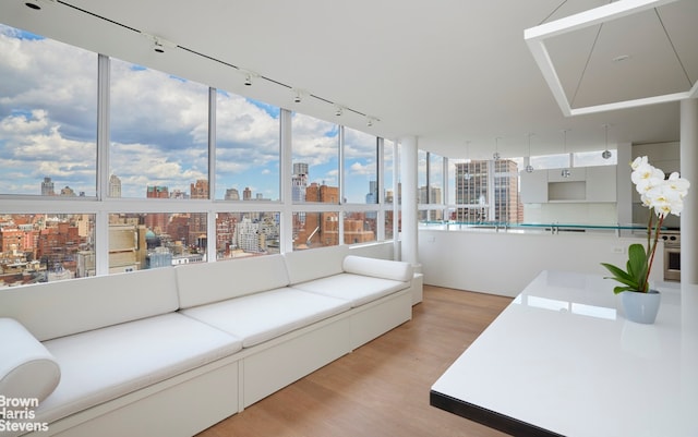 sunroom / solarium with rail lighting and a city view