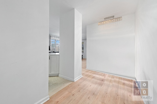 hallway with light wood finished floors and baseboards