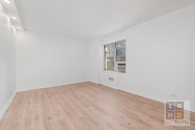 empty room with recessed lighting, cooling unit, baseboards, and wood finished floors