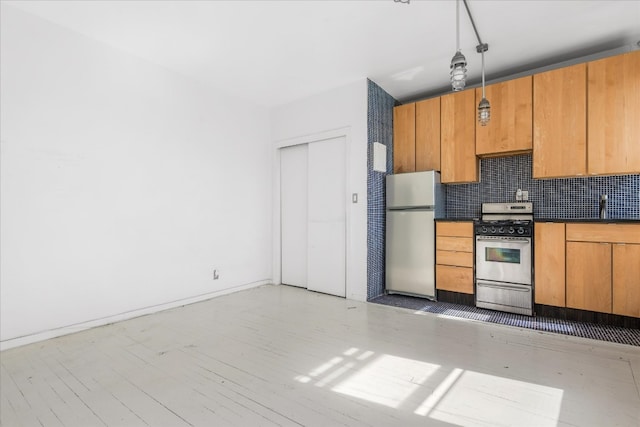 kitchen with appliances with stainless steel finishes, brown cabinets, tasteful backsplash, dark countertops, and pendant lighting