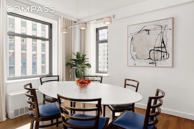 dining space with baseboards and wood finished floors