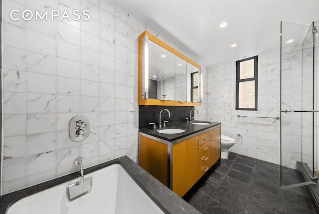 bathroom with a freestanding bath, tile walls, and a sink