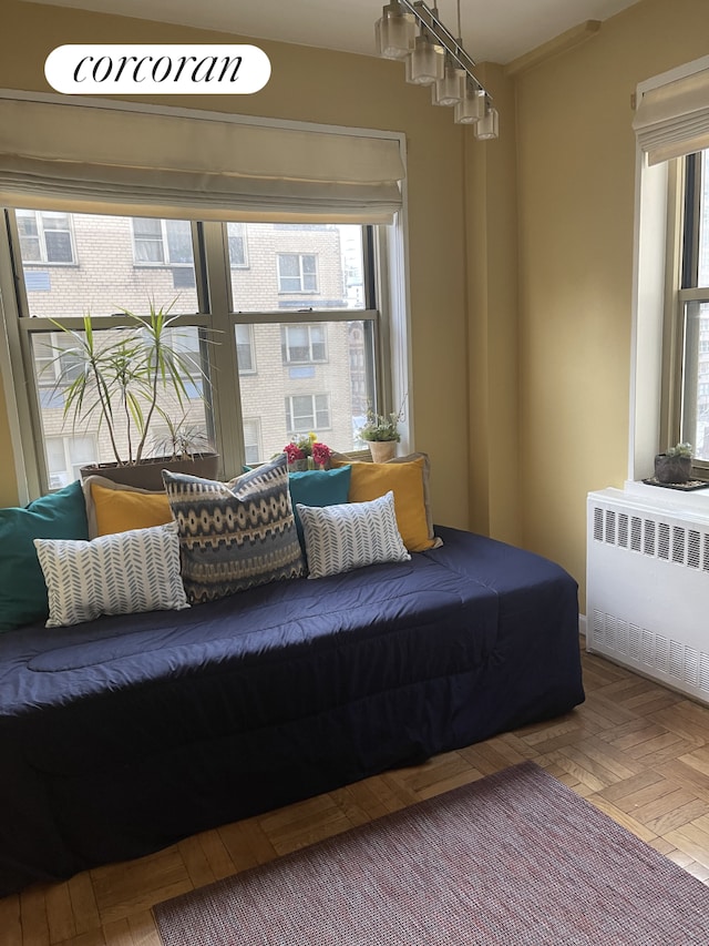 bedroom featuring multiple windows and radiator heating unit