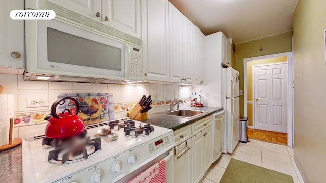 kitchen with decorative backsplash, white appliances, light tile patterned flooring, white cabinets, and sink