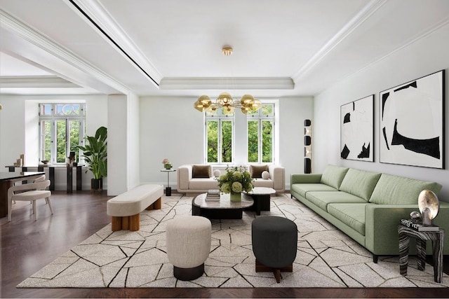 living room featuring plenty of natural light, a tray ceiling, ornamental molding, and a notable chandelier