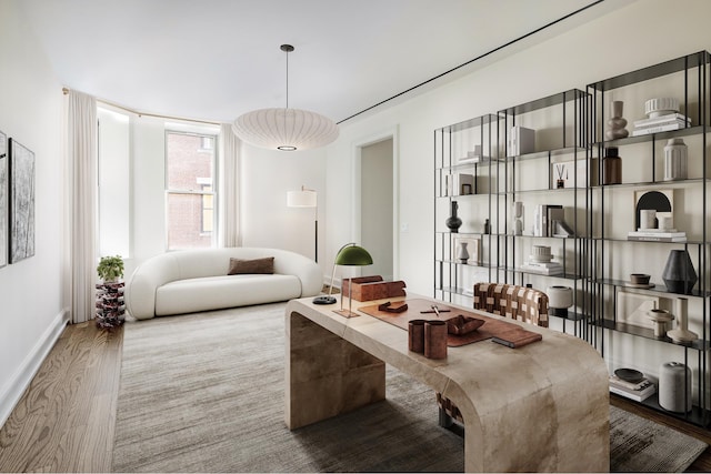 living area featuring baseboards and wood finished floors