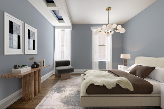 bedroom featuring baseboards, a notable chandelier, and wood finished floors