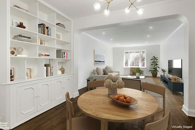 dining room featuring dark hardwood / wood-style flooring, a chandelier, ornamental molding, and built in shelves