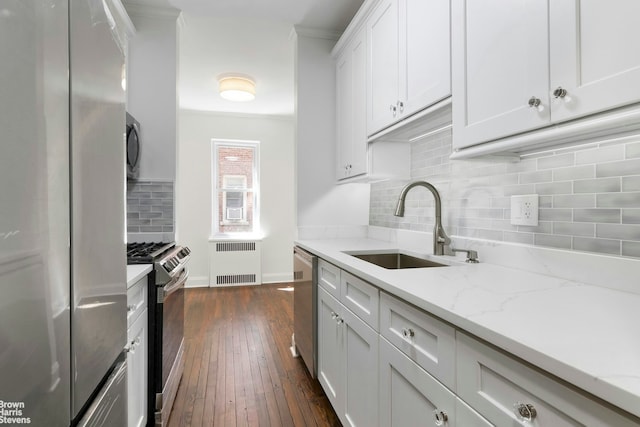 530 E 90th St Unit 2J, New York City, NY 10128 - kitchen featuring stainless steel appliances, radiator heating unit, a sink, backsplash, and dark wood finished floors