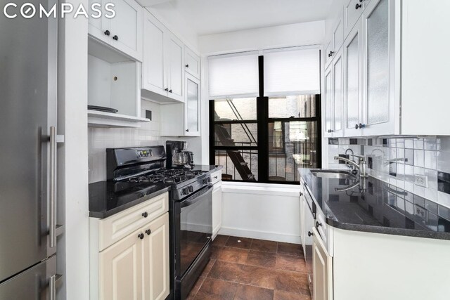 kitchen with white cabinets, high end refrigerator, sink, black gas stove, and backsplash