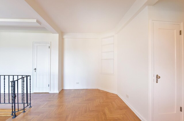 spare room featuring baseboards and built in features