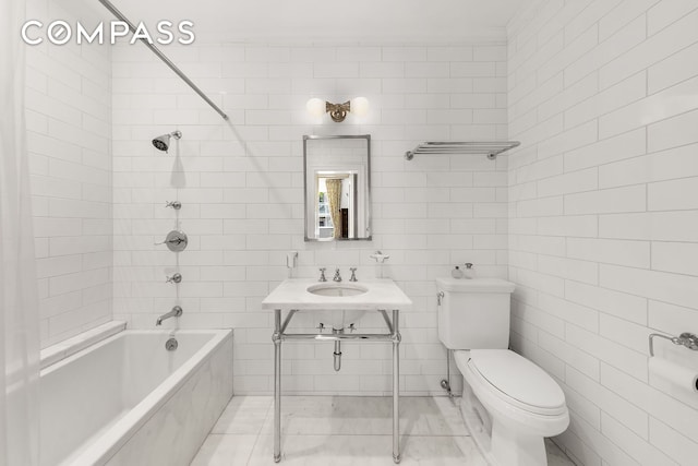 full bath featuring shower / tub combination, toilet, tile walls, and a sink