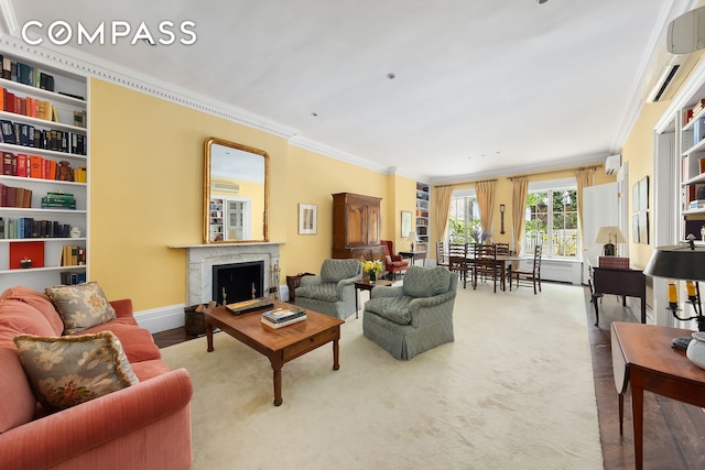 carpeted living area with baseboards, crown molding, a high end fireplace, and a wall unit AC