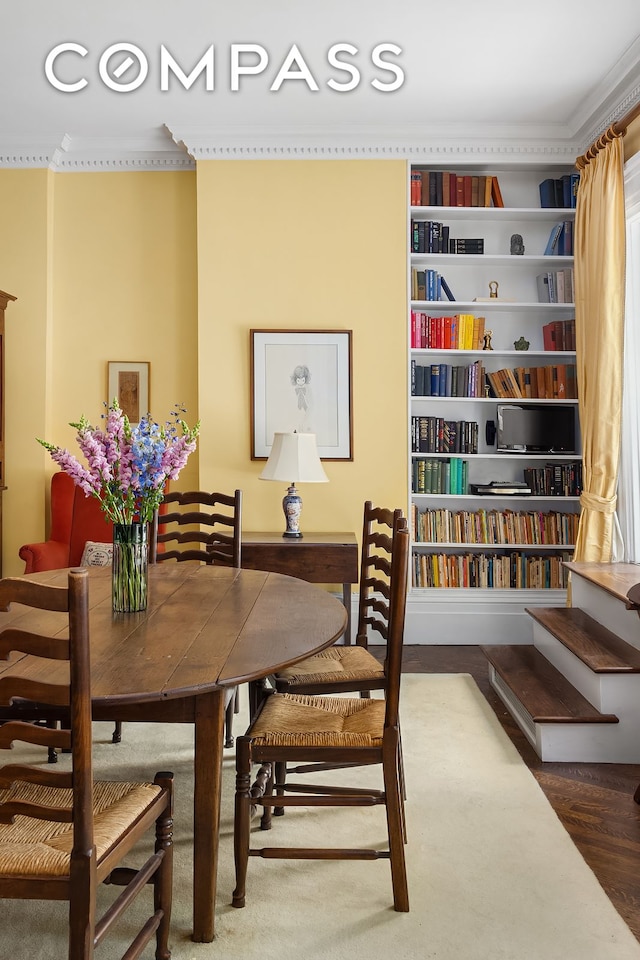 dining area with crown molding and wood finished floors