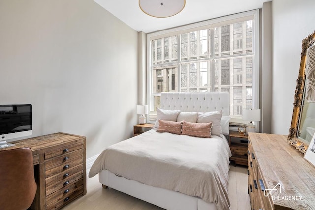 bedroom featuring light wood-type flooring and floor to ceiling windows